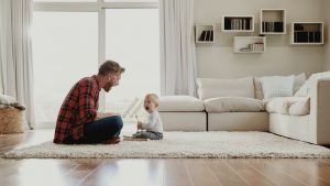 Young father and son playing together in their sitting room